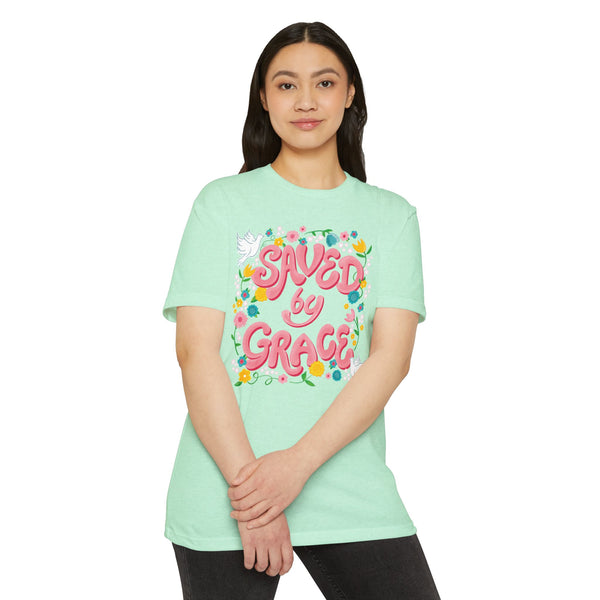 Person wearing a light green t-shirt with 'Saved by Grace' text and floral designs on a white background