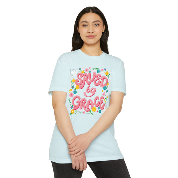 Person wearing a light blue t-shirt with 'Saved by Grace' text and floral design on a white background