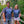 Husband and Wife wearing 'Walk on Water' Christian T Shirts standing on a wooden bridge with greenery in the background.